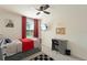 Bedroom featuring a comfortable bed with grey dresser, complemented by a window, modern desk and ceiling fan at 13734 Whiskey Daisy Dr, Dade City, FL 33525