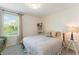 Bedroom featuring a comfortable bed with decorative pillows, complemented by a window and stylish corner shelving at 13734 Whiskey Daisy Dr, Dade City, FL 33525