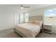 Cozy bedroom with natural light, plush bedding, neutral decor, and a ceiling fan at 13734 Whiskey Daisy Dr, Dade City, FL 33525