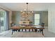 Inviting dining room features a wooden table, bench seating, modern lighting, and neutral décor at 13734 Whiskey Daisy Dr, Dade City, FL 33525