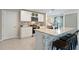 Bright kitchen featuring bar seating, stainless appliances, and white shaker cabinets at 13734 Whiskey Daisy Dr, Dade City, FL 33525