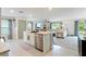 Open kitchen featuring a center island, stainless steel appliances, and a seamless flow to the living area at 13734 Whiskey Daisy Dr, Dade City, FL 33525