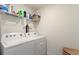 Functional laundry room with washer, dryer, shelving, and organized storage solutions at 13734 Whiskey Daisy Dr, Dade City, FL 33525