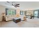 Spacious living area flowing into the dining area, featuring modern decor, ample natural light, and comfortable seating at 13734 Whiskey Daisy Dr, Dade City, FL 33525