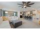 Open-concept living area flowing into the dining room and kitchen, featuring modern decor, ample natural light, and comfortable seating at 13734 Whiskey Daisy Dr, Dade City, FL 33525