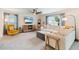 Bright living room with a ceiling fan, modern furniture, large windows with curtains, and neutral color palette at 13734 Whiskey Daisy Dr, Dade City, FL 33525