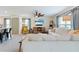 Bright living room featuring neutral tones, comfortable seating, and modern décor flowing to kitchen and dining area at 13734 Whiskey Daisy Dr, Dade City, FL 33525