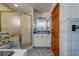 Bathroom featuring a tiled shower and vanity with blue accents, offering a modern and clean space at 17606 Lee Ave, Redington Shores, FL 33708