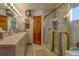 Bathroom featuring large vanity, glass shower and retro televisions at 17606 Lee Ave, Redington Shores, FL 33708