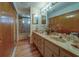 Bathroom featuring a dual-sink vanity, updated fixtures, and a shower with glass doors at 17606 Lee Ave, Redington Shores, FL 33708