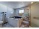 Bathroom with jacuzzi tub, shower, and steps up to a tiled bathing area with storage for toiletries at 17606 Lee Ave, Redington Shores, FL 33708