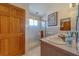Bathroom with double sinks, a tiled shower with glass doors, and a wood-paneled door at 17606 Lee Ave, Redington Shores, FL 33708