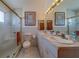 Bathroom with a tiled shower, vanity with double sinks, and decorative lighting at 17606 Lee Ave, Redington Shores, FL 33708