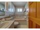 Cozy bathroom features a jacuzzi tub, toilet, and tiled walls, complete with stylish towel racks at 17606 Lee Ave, Redington Shores, FL 33708