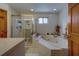 Bright bathroom featuring a jacuzzi tub and separate shower, complemented by tiled walls and floors at 17606 Lee Ave, Redington Shores, FL 33708