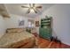 Bedroom features hardwood floors, a ceiling fan, comfortable bed and decorative hutch at 17606 Lee Ave, Redington Shores, FL 33708