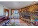 Cozy living room featuring a stone fireplace, plush leather furniture, and an ocean view at 17606 Lee Ave, Redington Shores, FL 33708