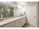 Bathroom featuring double sinks, granite countertops, and tiled shower with glass door at 17847 Althea Blue Pl, Lutz, FL 33558