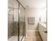 Bathroom with a tiled shower, granite countertops, and wood-look tile flooring at 17847 Althea Blue Pl, Lutz, FL 33558