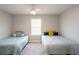Bright bedroom with two twin beds, neutral walls, ceiling fan, and comfortable sleeping space at 17847 Althea Blue Pl, Lutz, FL 33558