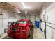 Garage featuring a parked red car and storage shelves at 17847 Althea Blue Pl, Lutz, FL 33558
