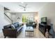 Comfortable living room with tile flooring, ceiling fan, and sliding glass door leading to a patio at 17847 Althea Blue Pl, Lutz, FL 33558