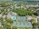 Aerial view showcasing community amenities, including tennis courts, pool, and clubhouse near the lake at 18002 Avalon Ln, Tampa, FL 33647