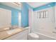 Bright bathroom with blue accent wall, vanity, sink, faucet, large mirror, toilet and bathtub at 18002 Avalon Ln, Tampa, FL 33647
