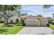 Stunning single-story home featuring a terracotta roof, lush landscaping, and an attached three-car garage at 18002 Avalon Ln, Tampa, FL 33647