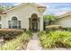 Charming front entrance featuring a beautifully landscaped walkway, arched entryway, and glass front door at 18002 Avalon Ln, Tampa, FL 33647