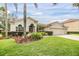 Attractive home featuring a terracotta roof, lush landscaping, and a three-car garage at 18002 Avalon Ln, Tampa, FL 33647