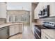 Bright kitchen features white cabinets, stainless steel appliances, and views of the landscaped backyard at 18002 Avalon Ln, Tampa, FL 33647