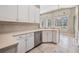 Open kitchen with white cabinets, stainless steel dishwasher, and scenic window at 18002 Avalon Ln, Tampa, FL 33647