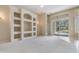 Spacious living room with custom built-in shelving and sliding glass doors that offer a pool view at 18002 Avalon Ln, Tampa, FL 33647