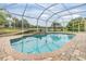 Sparkling screened-in pool overlooking a tranquil pond, creating a relaxing backyard retreat at 18002 Avalon Ln, Tampa, FL 33647
