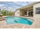 Screened-in pool with brick trim and covered patio, offering a relaxing outdoor space at 18002 Avalon Ln, Tampa, FL 33647