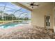 Beautiful pool and screened patio with an outdoor ceiling fan and a view of the lake at 18002 Avalon Ln, Tampa, FL 33647