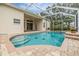 Inviting screened-in pool with brick trim and tile, palm trees and a view of the home at 18002 Avalon Ln, Tampa, FL 33647
