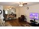 Bright living room with ceiling fan, hardwood floors, television and adjacent dining area at 2020 World Parkway Blvd # 12, Clearwater, FL 33763