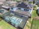 Aerial view of a home with a screened-in pool, lush landscaping, and solar panels at 2641 Whittler Br, Odessa, FL 33556