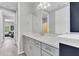 Bathroom with gray cabinets, white countertop, and a view into an adjacent living space at 2641 Whittler Br, Odessa, FL 33556