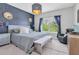 Primary bedroom with an elegant accent wall, large windows, and stylish furnishings at 2641 Whittler Br, Odessa, FL 33556