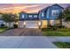 Beautiful two-story home with a three-car garage and attractive landscaping at sunset at 2641 Whittler Br, Odessa, FL 33556