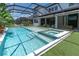 Resort-style pool with a spa, sun shelf, and screened enclosure at 2641 Whittler Br, Odessa, FL 33556