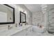 Elegant bathroom featuring marble tile, a soaking tub, and a dual sink vanity with stylish modern lighting at 2722 Via Tivoli # 430A, Clearwater, FL 33764
