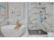 Bathroom showcasing a modern soaking tub, walk-in glass shower with marble tile and chrome shower head at 2722 Via Tivoli # 430A, Clearwater, FL 33764