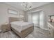Cozy bedroom featuring a comfortable bed, gray wood flooring, and a sunlit window with sheer curtains at 2722 Via Tivoli # 430A, Clearwater, FL 33764