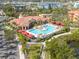 Aerial view of a resort-style community pool with cabanas, lounge chairs, and lush tropical landscaping at 2722 Via Tivoli # 430A, Clearwater, FL 33764