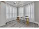 Dining area with white and gold decor, white drapes, modern light fixture, and wood-look flooring at 2722 Via Tivoli # 430A, Clearwater, FL 33764