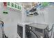 Bright laundry room with modern washer and dryer, plus shelving for storage at 2722 Via Tivoli # 430A, Clearwater, FL 33764